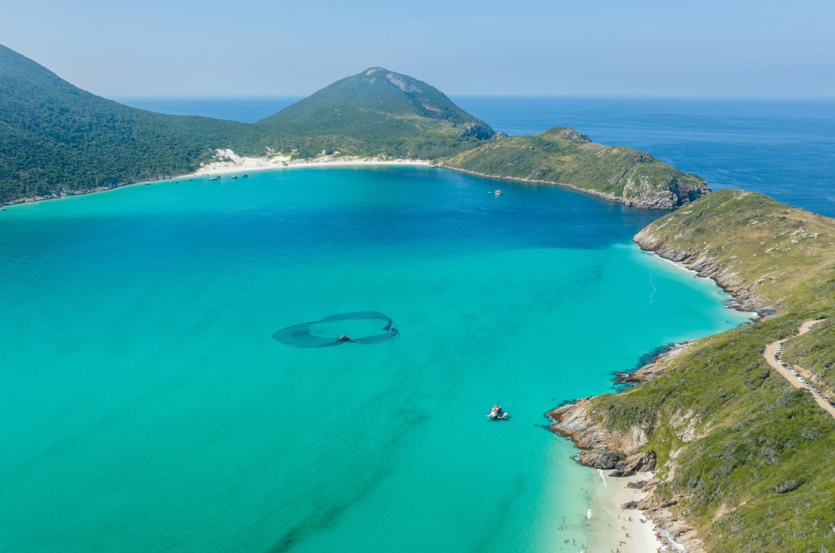 Vista aérea de las playas de Arraial do Cabo en Brasil, mostrando aguas turquesas cristalinas, arena blanca y barcos de excursión privados en la costa de Río de Janeiro.