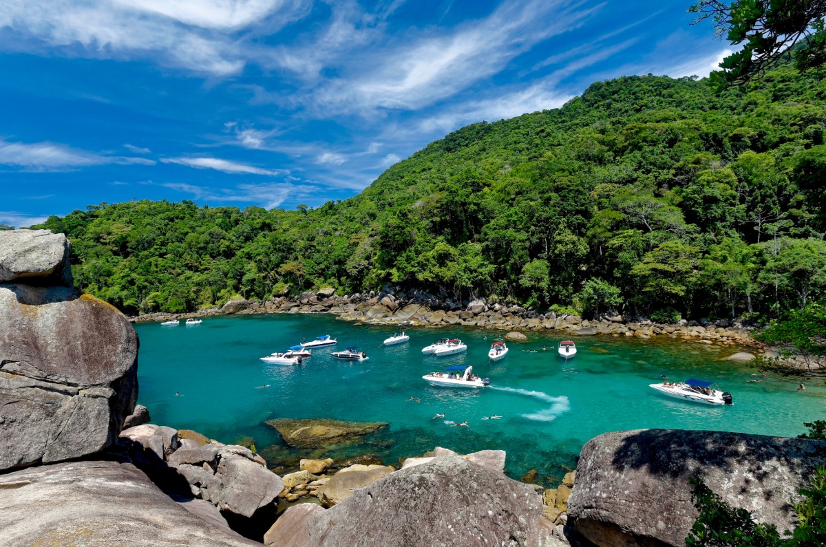 Lanchas fondeadas en una ensenada de aguas turquesas y vegetación tropical en la costa de Ilha Grande, Brasil.