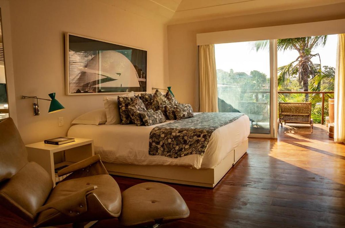 Habitación de lujo en el Insólito Boutique Hotel & Spa en Búzios, con cama king size, decoración de diseño y terraza con vistas a la naturaleza.