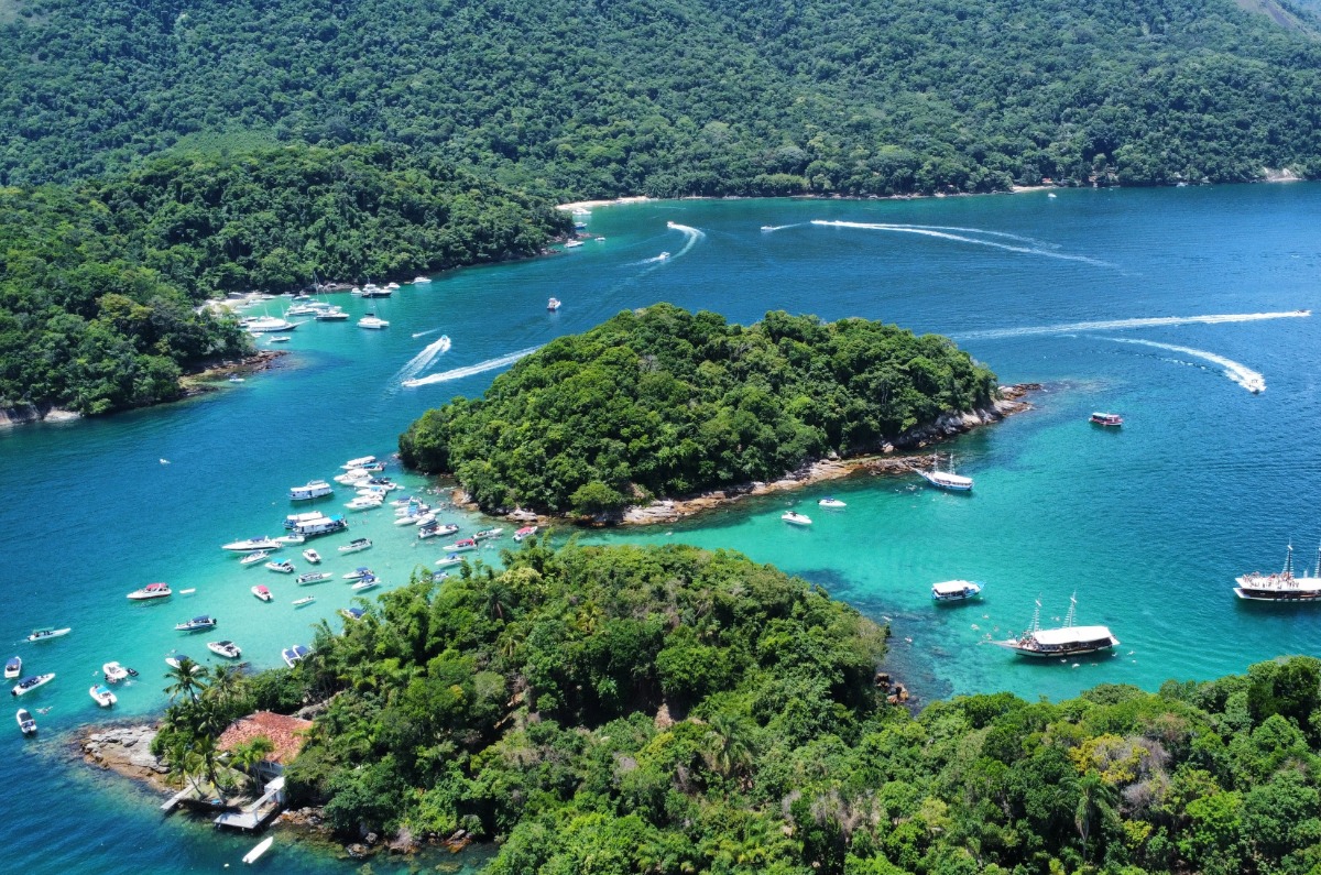 Vista panorámica de Lagoa Azul en Ilha Grande con embarcaciones fondeadas en sus aguas transparentes rodeadas de islotes verdes.