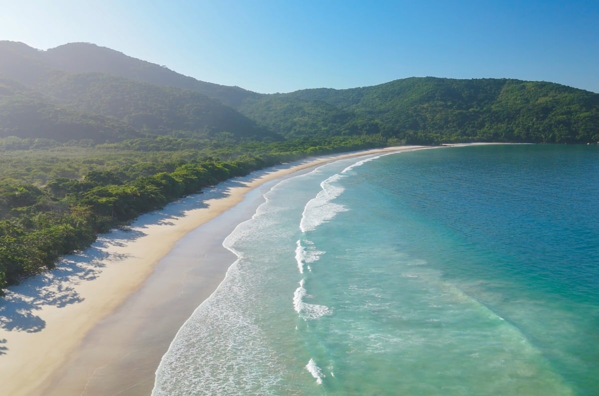 Vista aérea de la extensa playa virgen de arena blanca y mar turquesa de Lopes Mendes en Ilha Grande, Brasil.