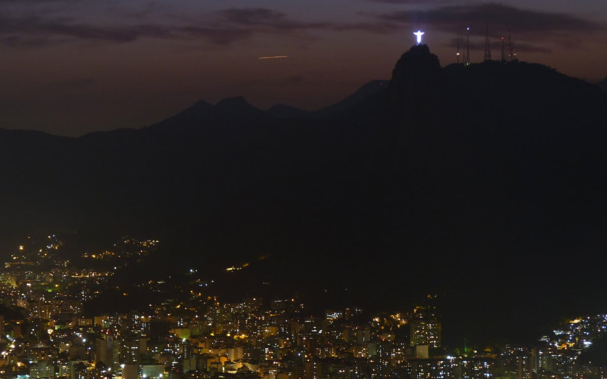Vista nocturna de Río de Janeiro con el Cristo Redentor iluminado en lo alto del Corcovado.