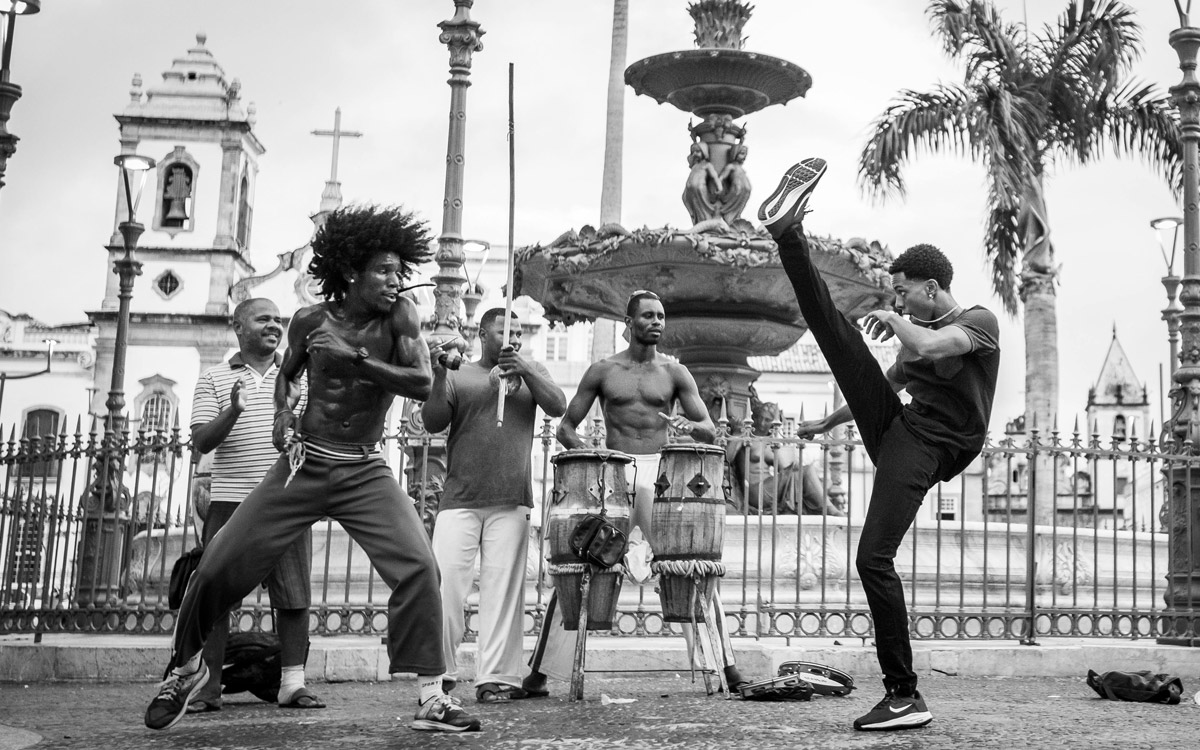 Exhibición de capoeira en una plaza de Salvador de Bahía, Brasil, con música en vivo y tambores.